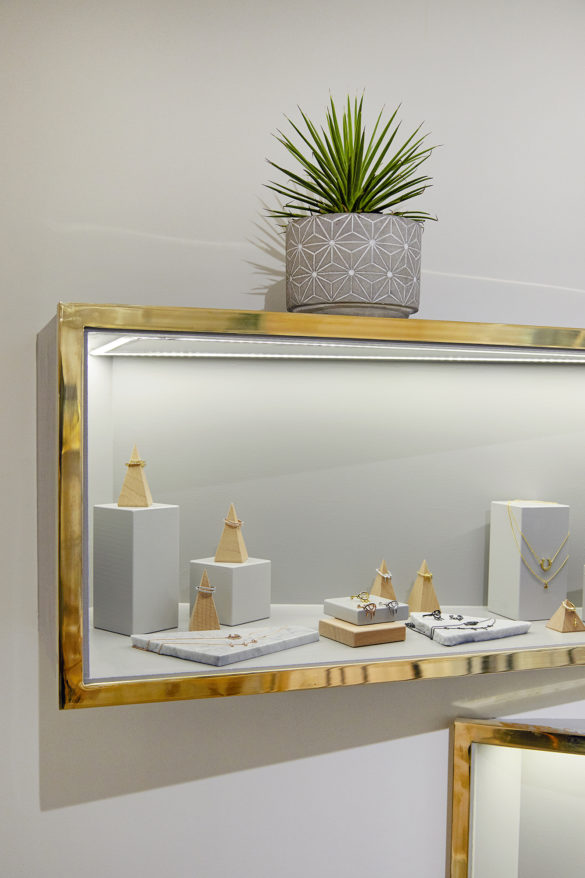 House of Sylphina commercial interior design for Astrid and Miyu flagship, London. Gold trim shelving with plant detail.